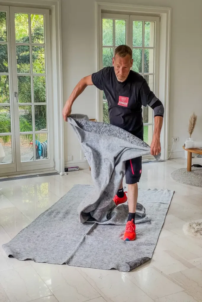 Mitarbeiter der Umzugsfirma Junker bereitet Möbeldecken zum Schutz empfindlicher Möbel vor.