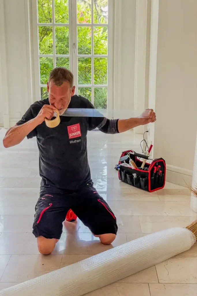 Mitarbeiter der Umzugsfirma Junker bereitet Verpackungsmaterial vor – sorgfältige Umzugsvorbereitung mit Profi-Ausrüstung.