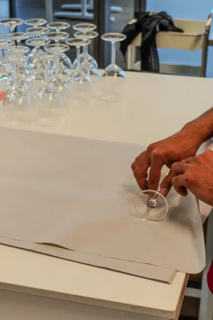 Mitarbeiter verpackt ein Weinglas sorgfältig in Packpapier für den Umzug