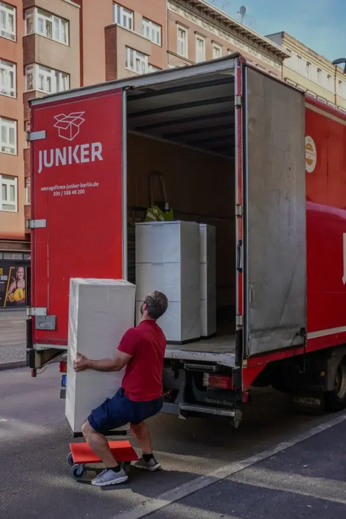 Mitarbeiter der Umzugsfirma Junker lädt einen verpackten Aktenschrank in einen LKW