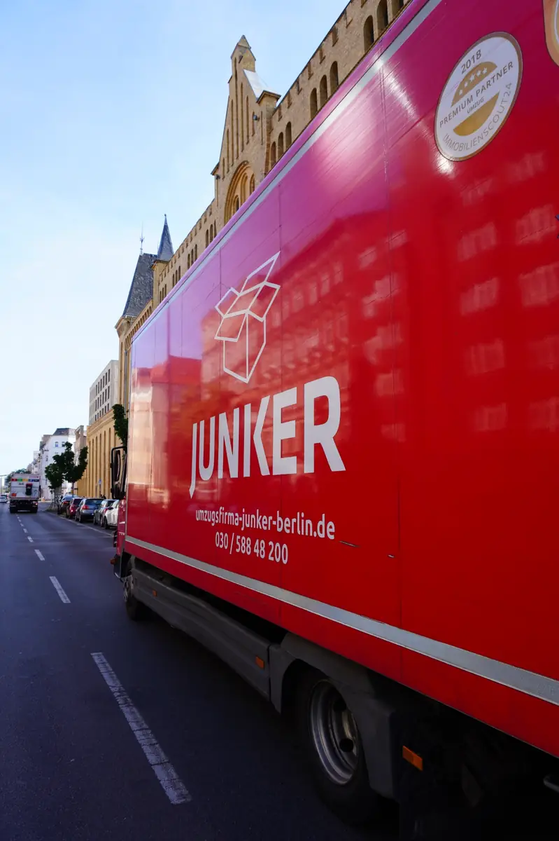 Roter Umzugs-LKW der Umzugsfirma Junker vor einer Häuserzeile