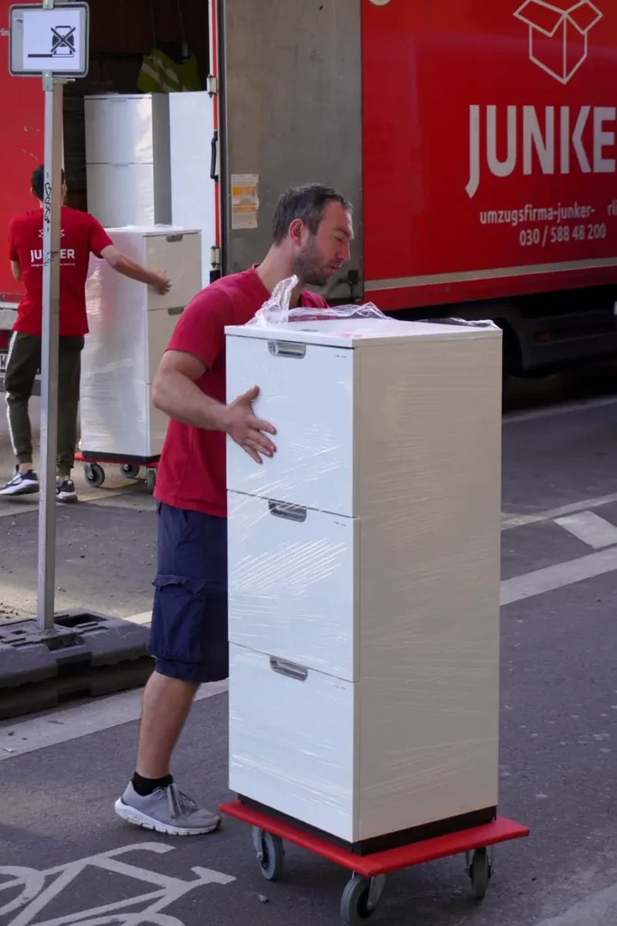 Umzugshelfer der Junker Umzugsfirma transportiert Möbel in Berlin