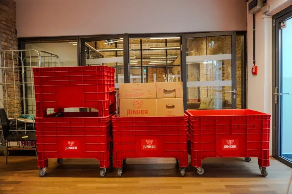 Rote Transportboxen und Umzugskartons der Junker Umzugsfirma auf Rollwagen