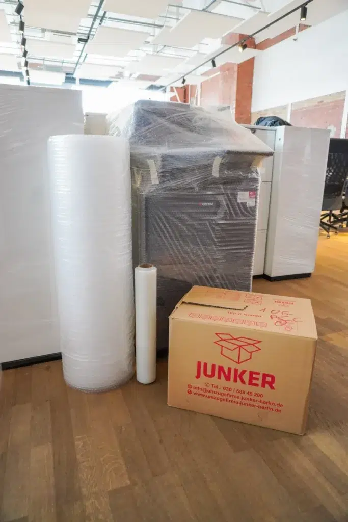 Verpackungsmaterial und eingewickelte Büromöbel für einen Firmenumzug